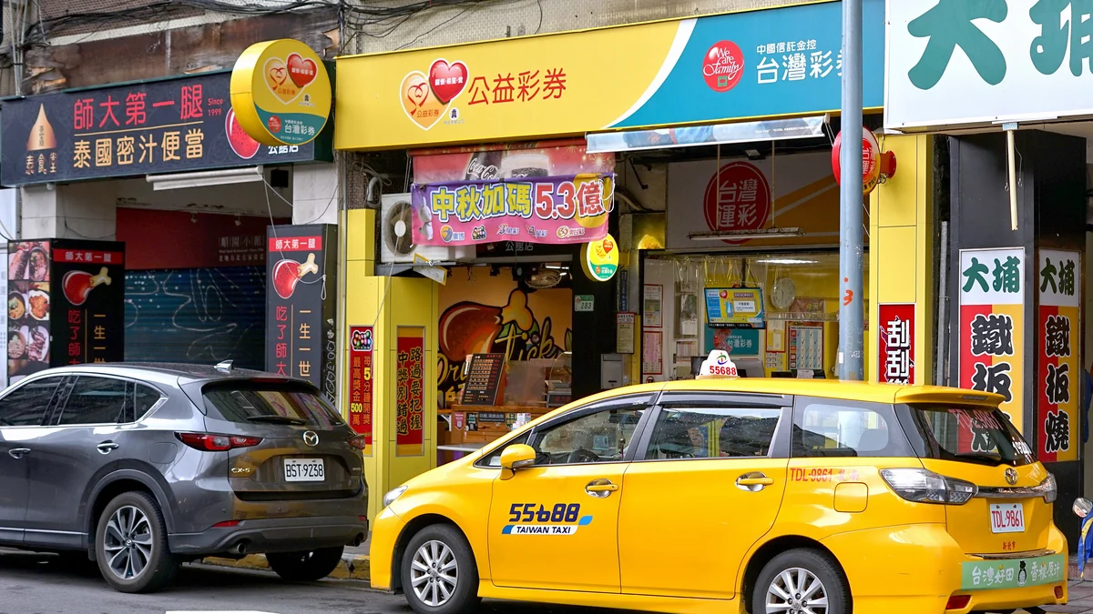 今彩539 投注站實拍：中國信託・台灣彩券公益彩券門市，掛著公益彩券、台灣運彩招牌與『中獎別錯過』刮刮樂布條——今彩539天天開獎，這種店就是買號、對獎、抄下開獎號碼畫版路的第一線（圖：Wikimedia Commons，CC BY-SA 4.0，2024年攝）